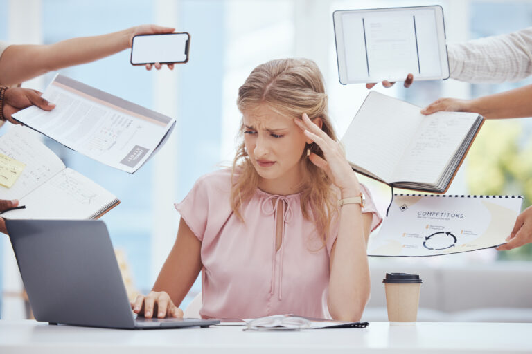 A business professional feeling stressed and overwhelmed at work.