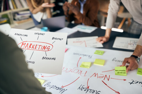 A team of marketing professionals brainstorming, with plans and notes on their table.
