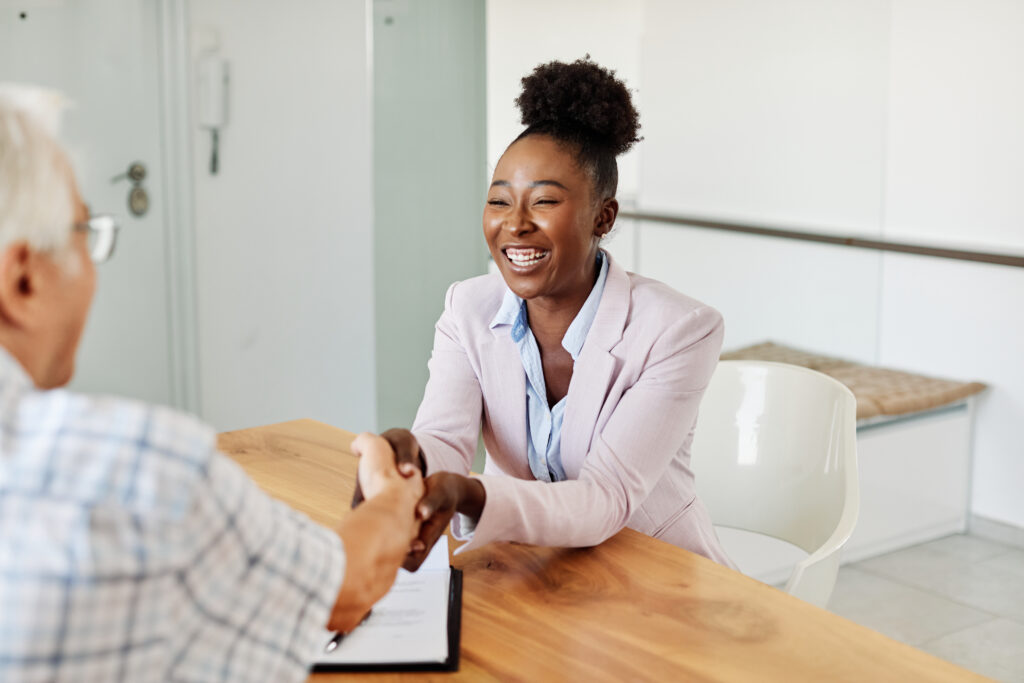 A sales representative happily shaking hands with her client.