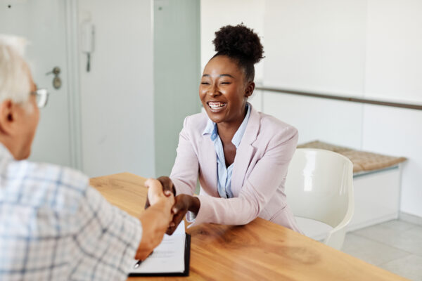 A sales representative happily shaking hands with her client.