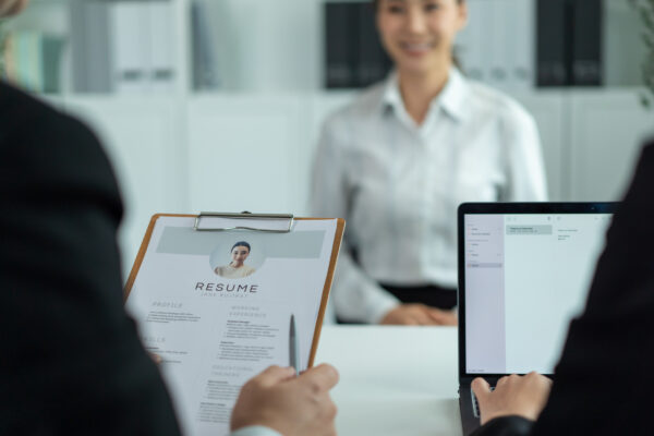 A job applicant being interviewed by two recruiters in an office setting.